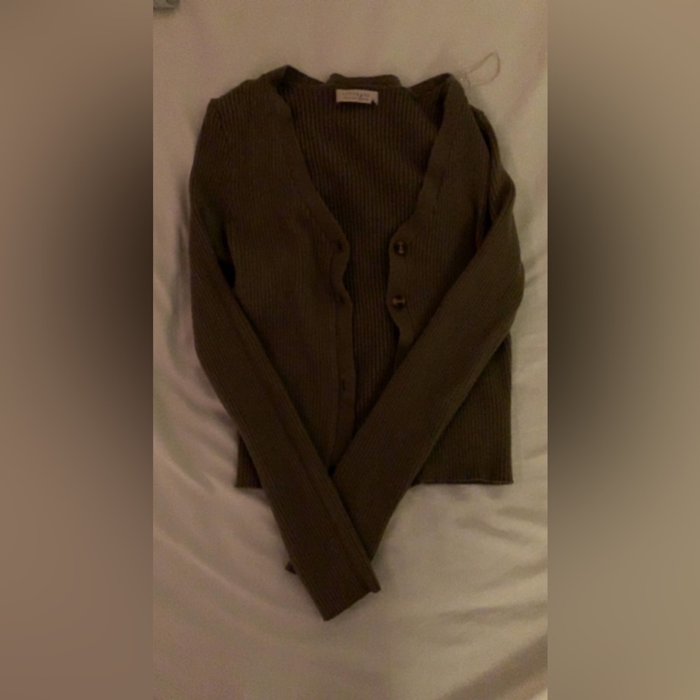 Green cardigan type button up. Its a bit itchy so you should wear a tank under.